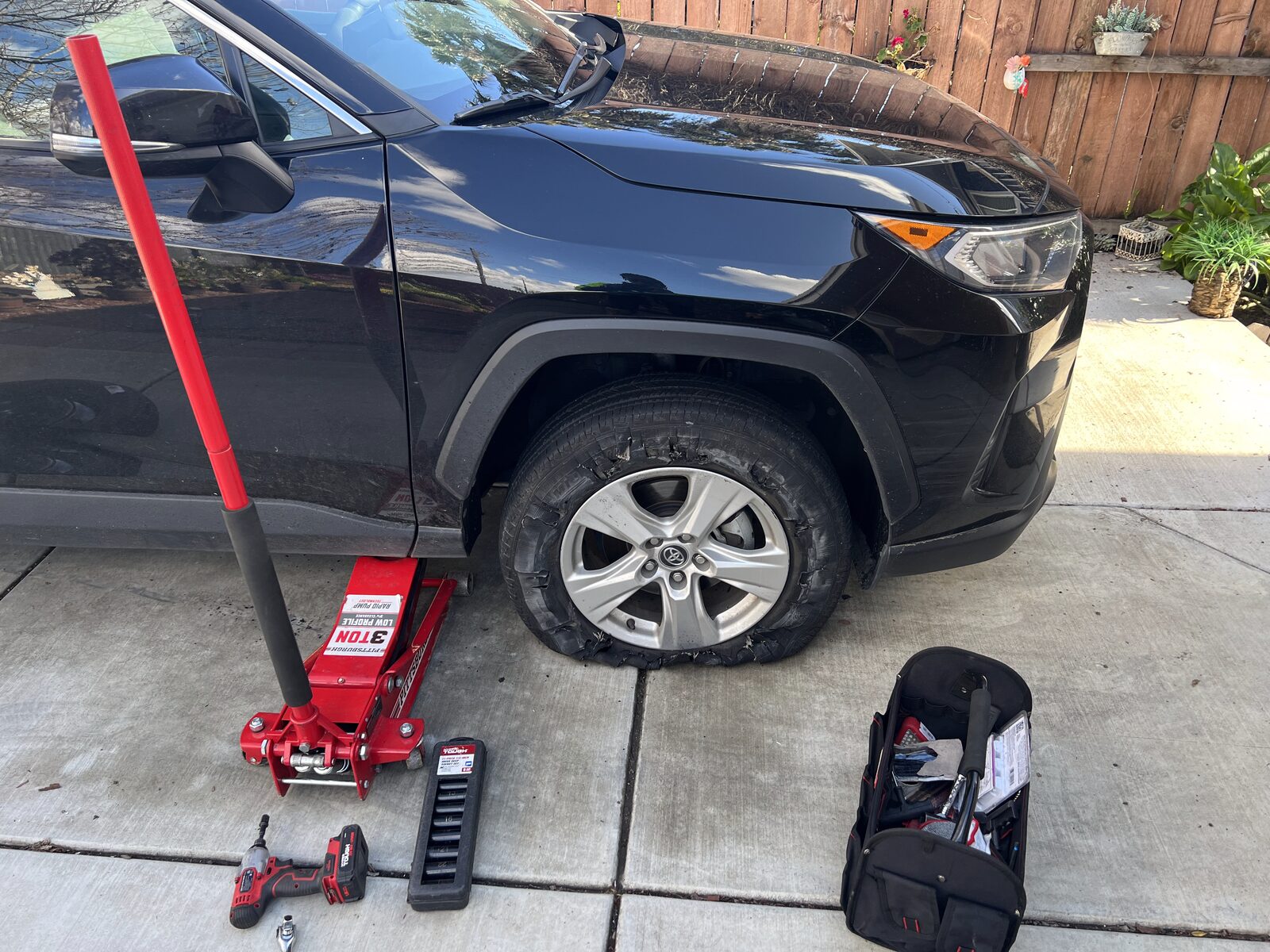 CB Roadside changing a tire in a customer driveway
