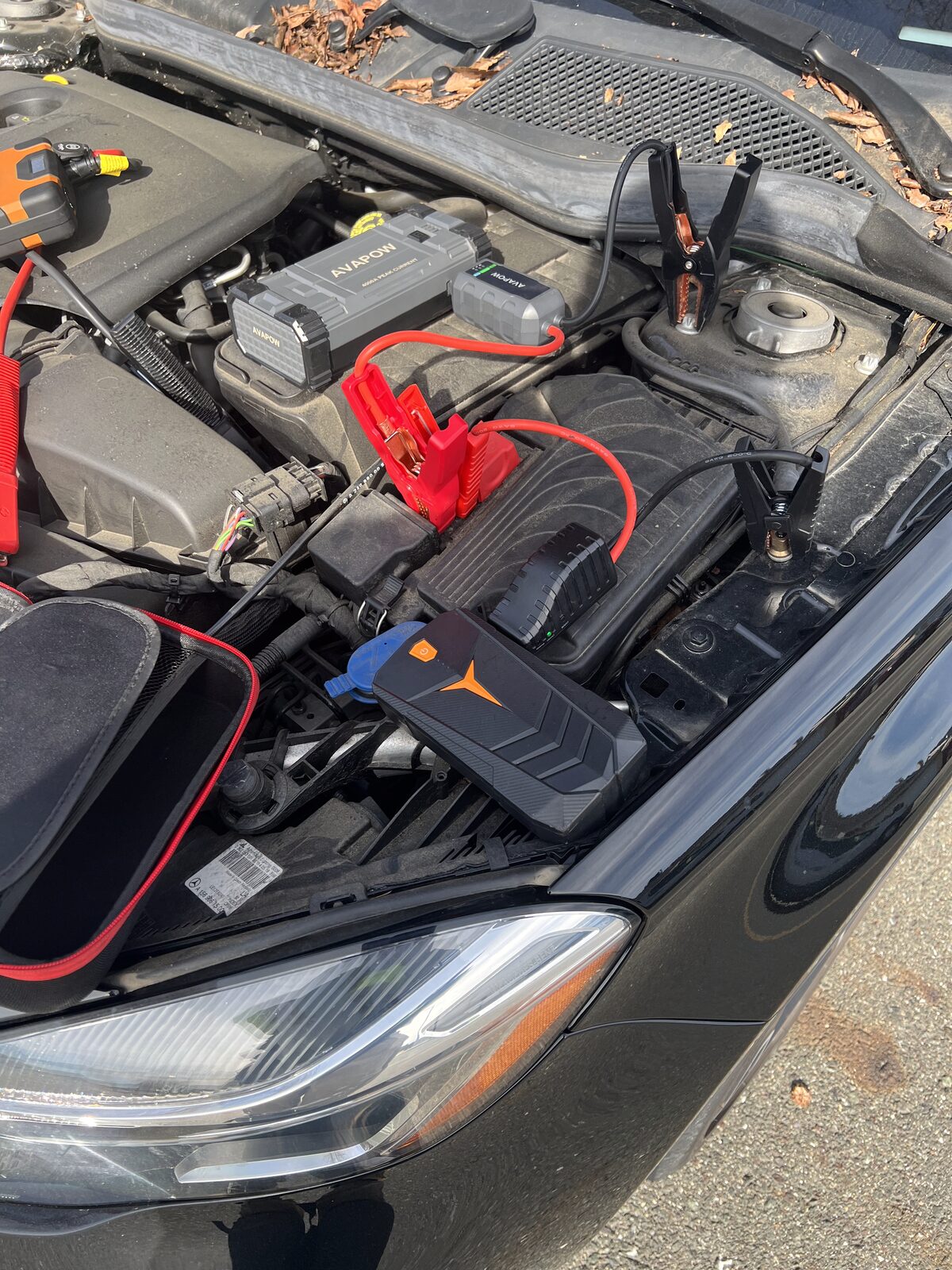Jump pack connected to a car battery during a roadside jump start