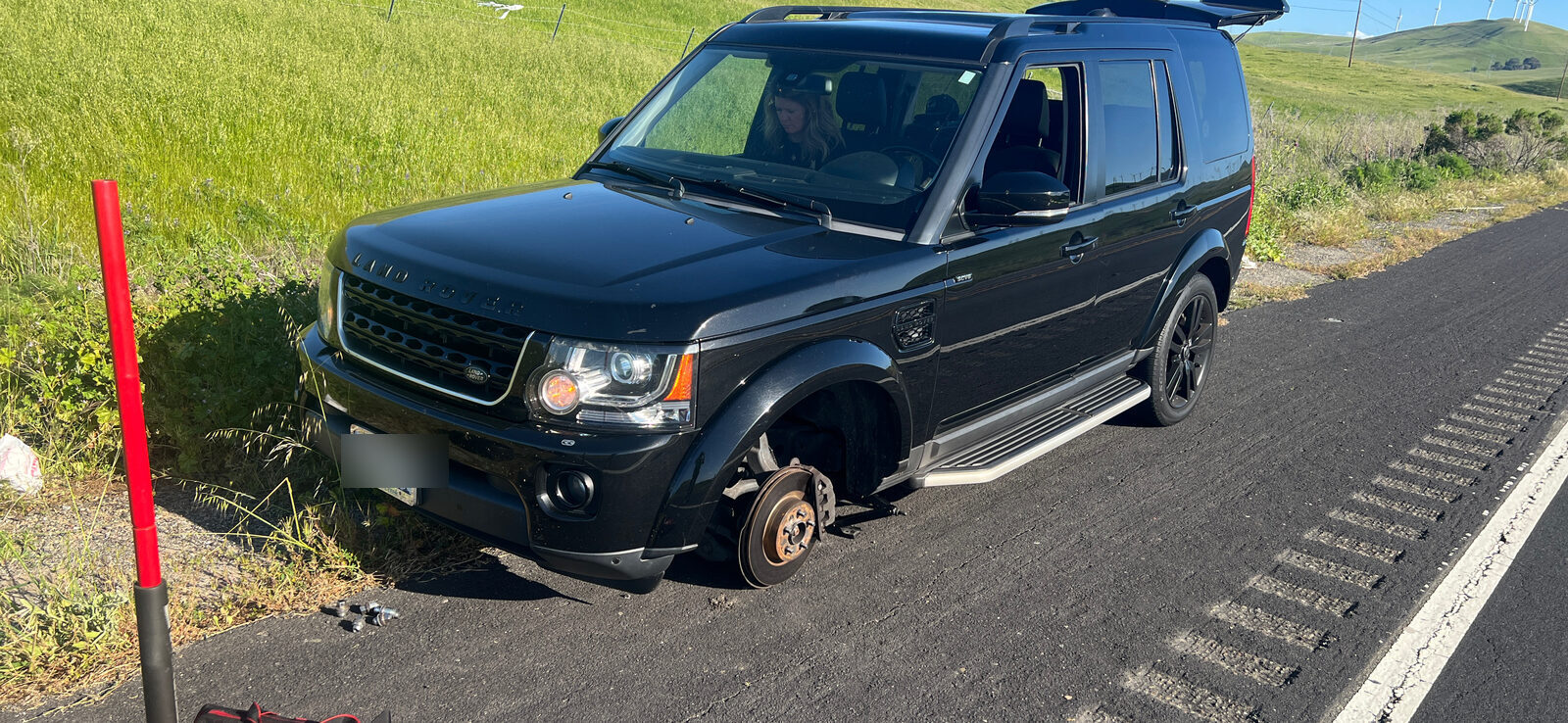 SUV with wheel removed on a rural roadside, serviced by CB Roadside Assistance
